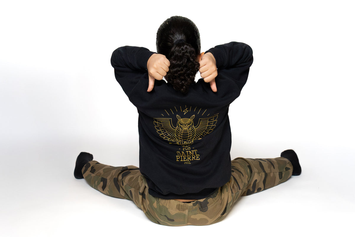 Back view of a child in the kids Pub Saint Pierre crewneck, gold owl graphic across the back