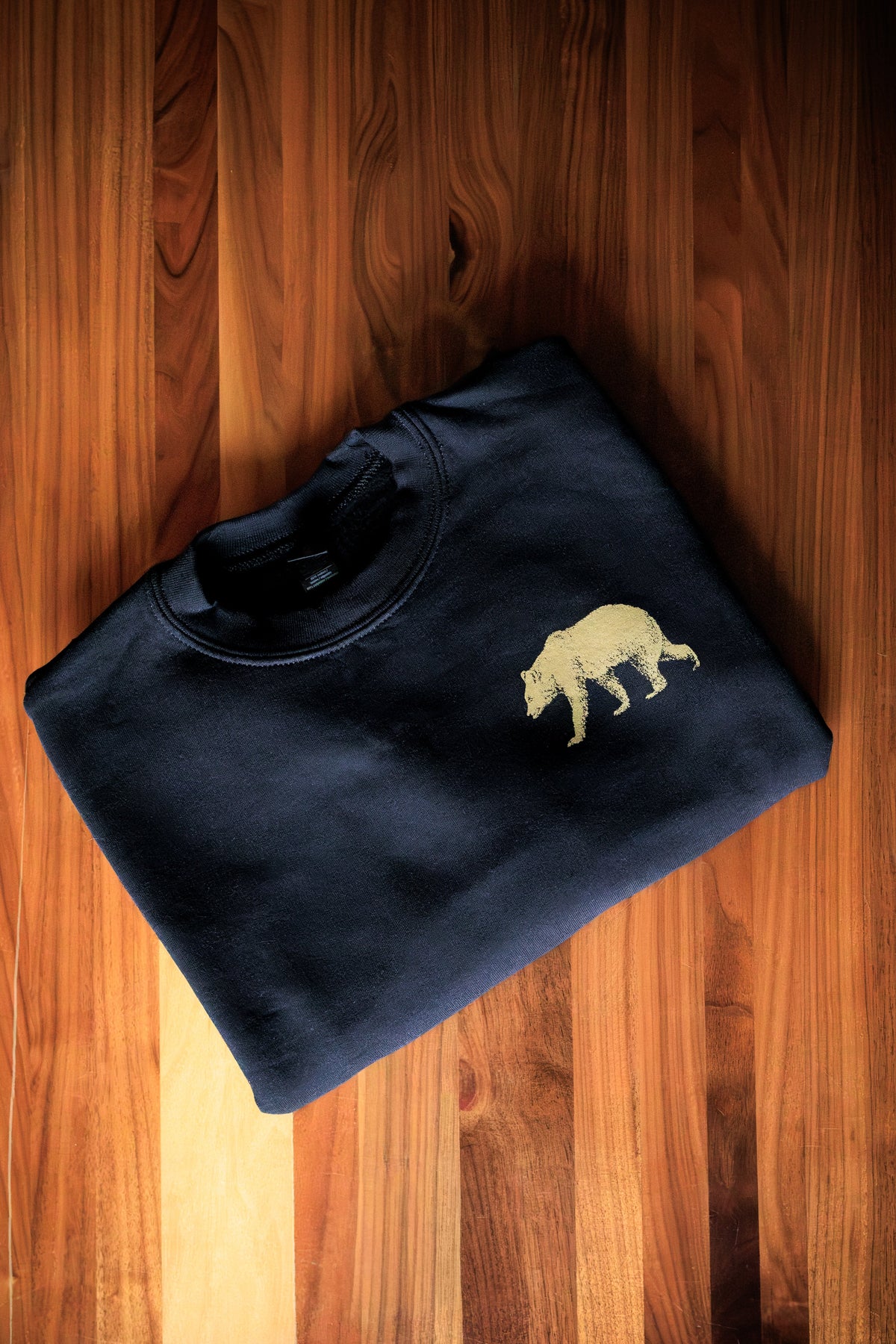 Black Pub Saint Pierre crewneck fleece folded on a walnut table