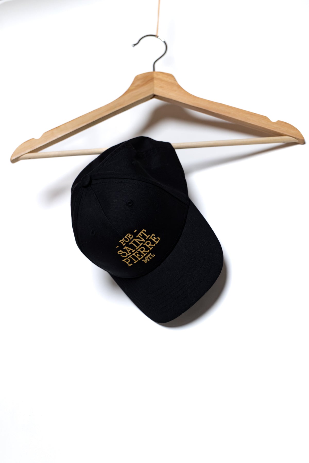 Navy Pub Saint Pierre baseball cap on a white background, gold embroidered wordmark on the front panel
