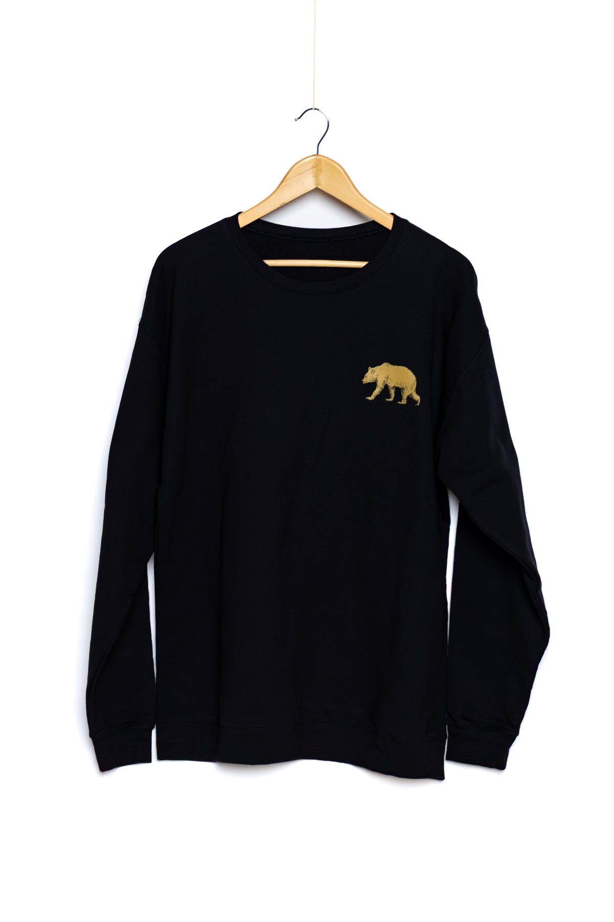 Front of the black Pub Saint Pierre crewneck sweatshirt on a white background, gold bear at the chest