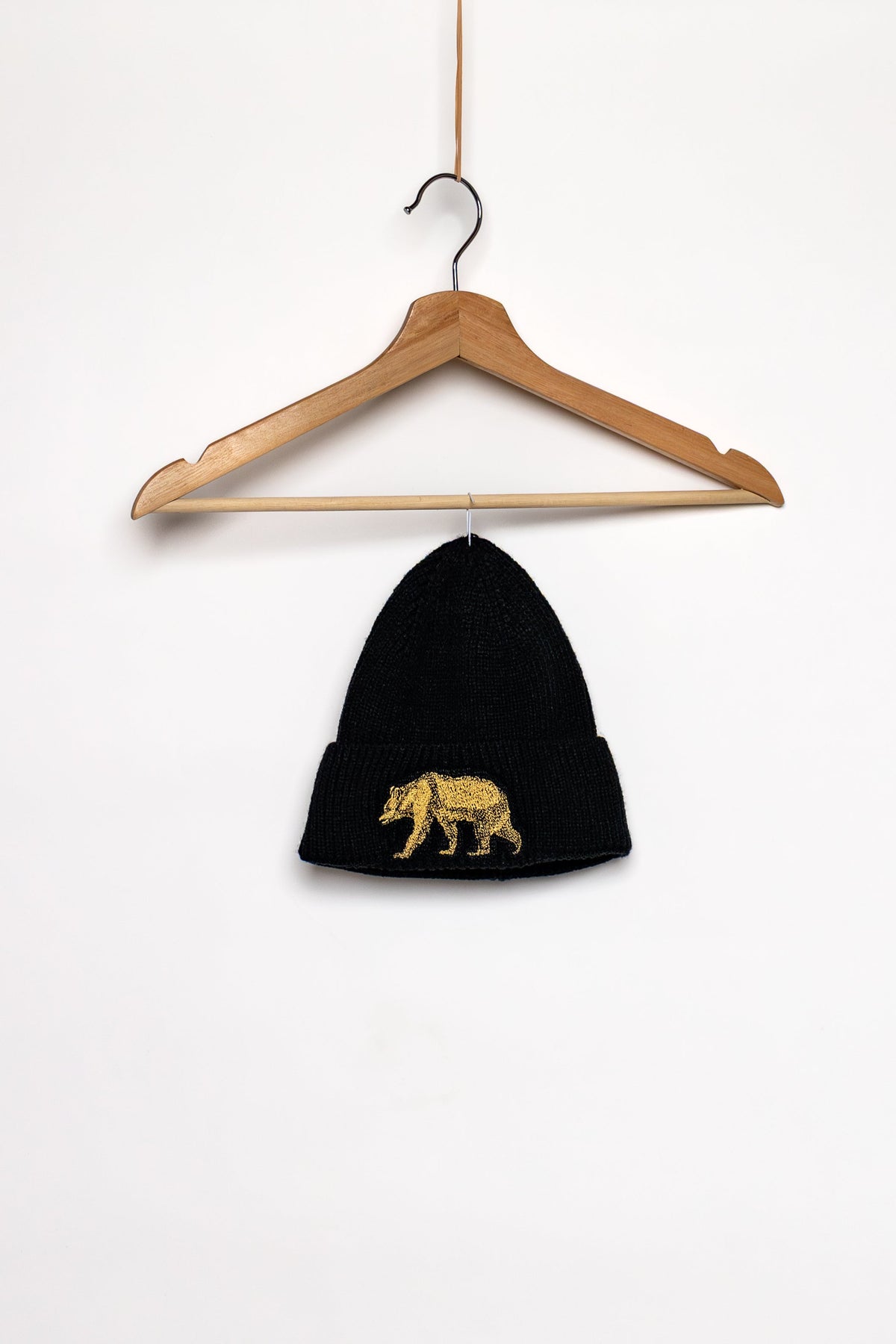 Black Pub Saint Pierre toque on a white background, gold bear on the cuff