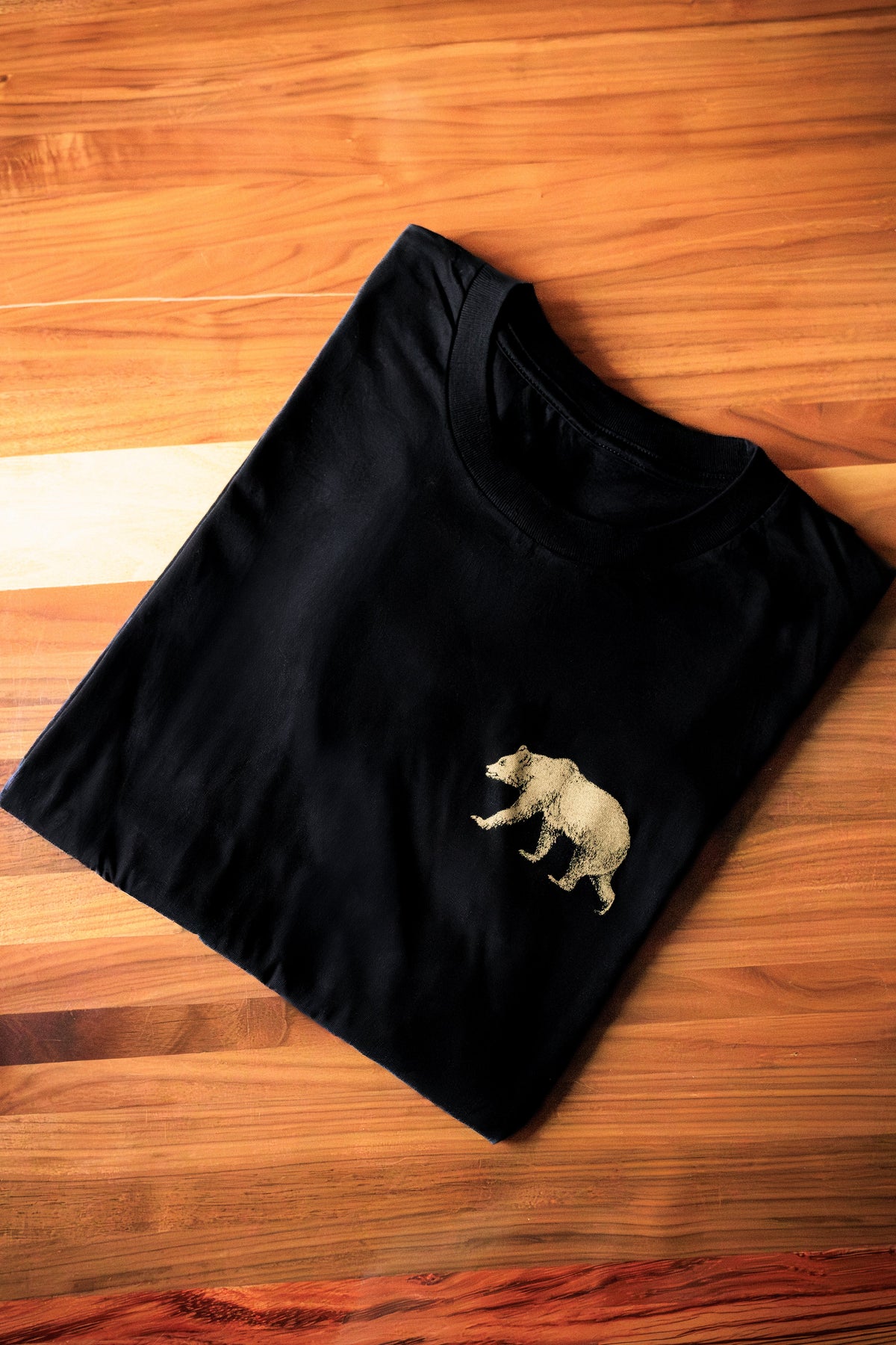 Black Pub Saint Pierre fine jersey t-shirt laid flat on a walnut table
