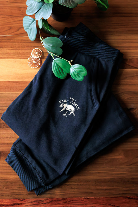 Black Pub Saint Pierre joggers folded on a walnut table